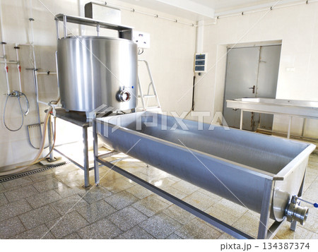 A cylindrical metal tank connected to a long rectangular bath. 134387374