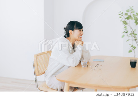 リビングのテーブルで談笑する女性 134387912