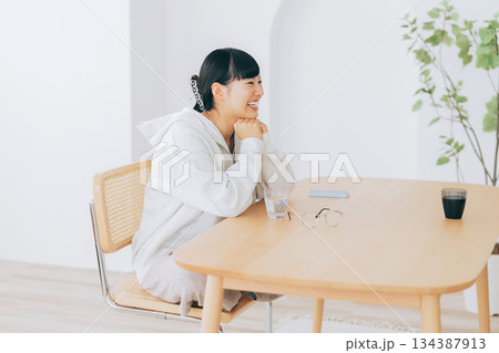 リビングのテーブルで談笑する女性 リビングのテーブルで談笑する女性 134387913