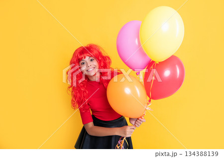 positive kid with party balloon on yellow background positive kid with party balloon on yellow background 134388139