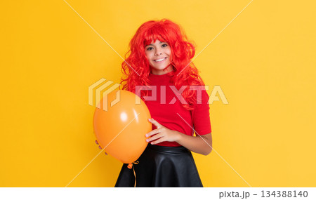girl smile with party balloon on yellow background 134388140