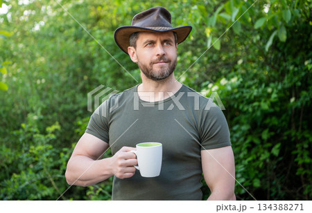 photo of cheerful cowboy man with coffee. cowboy man with coffee. cowboy man with coffee in hat. photo of cheerful cowboy man with coffee. cowboy man with coffee. cowboy man with coffee in hat. 134388271