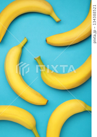 Yellow bananas flat lay on blue background. Vertical photo 134388521