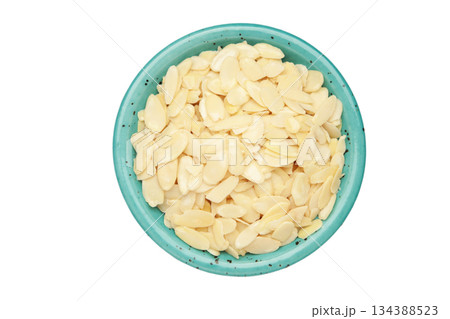Fresh almond flakes in plate isolated on white background, closeup Fresh almond flakes in plate isolated on white background, closeup 134388523