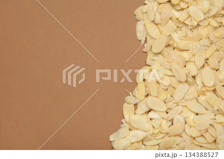 Fresh almond flakes on brown background 134388527