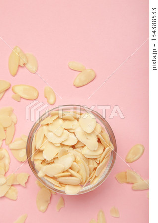 Fresh almond flakes in bowl on pink background. Vertical photo Fresh almond flakes in bowl on pink background. Vertical photo 134388533