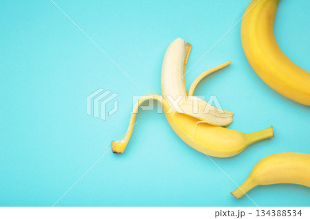 Open ripe banana on blue background. Space for text Open ripe banana on blue background. Space for text 134388534
