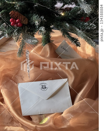 Christmas tree with festive letter envelopes on orange fabric background, perfect for holiday themes Christmas tree with festive letter envelopes on orange fabric background, perfect for holiday themes 134388884