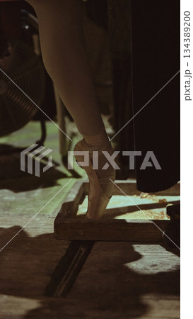 Ballet dancer on pointe backstage preparing for final theater performance. 134389200