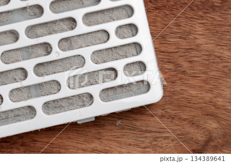 Clogged and dust blocked air filter cartridge on a wooden surface close up Clogged and dust blocked air filter cartridge on a wooden surface close up 134389641