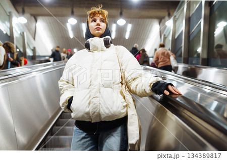 young woman in white winter jacket in the underground metro young woman in white winter jacket in the underground metro 134389817