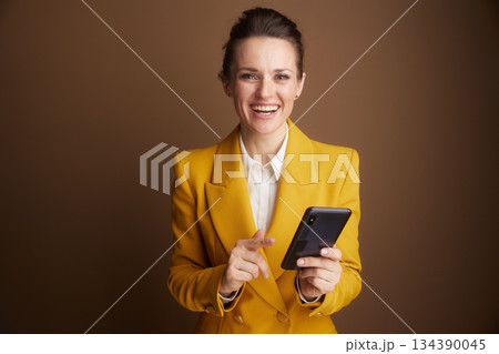 Smiling Businesswoman Pointing to Smartphone 134390045