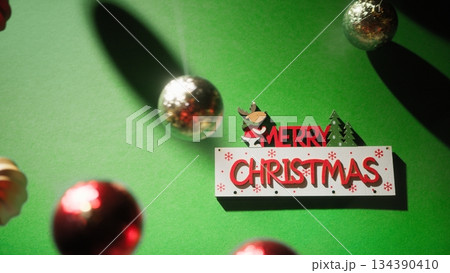 Merry Christmas Text Over Swinging Balls Merry Christmas Text Over Swinging Balls 134390410