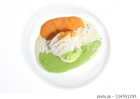 Idli served with tricolor chutney on a white plate 134391295