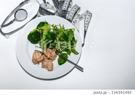 Healthy diet concept with tuna broccoli salad and medical tools. Healthy diet concept with tuna broccoli salad and medical tools. 134391493