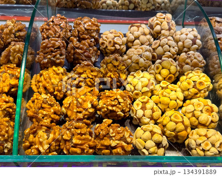Nut and fruit based sweets arranged in compact clusters inside a display case in Istanbul bazaar. Traditional confectionery, natural energy foods, and artisanal craftsmanship presented through texture 134391889