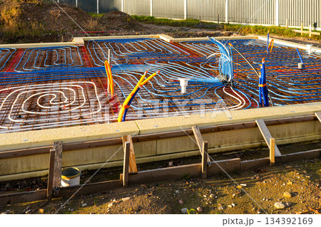 Underfloor heating pipes installed on reinforced rebar grid before concrete slab pouring Underfloor heating pipes installed on reinforced rebar grid before concrete slab pouring 134392169