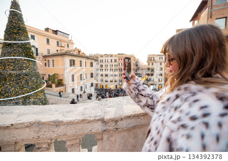 Woman photographing festive city view near the Spanish Steps in Rome 134392378