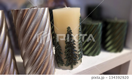 Festive holiday candles with Christmas tree designs for seasonal decoration 134392920