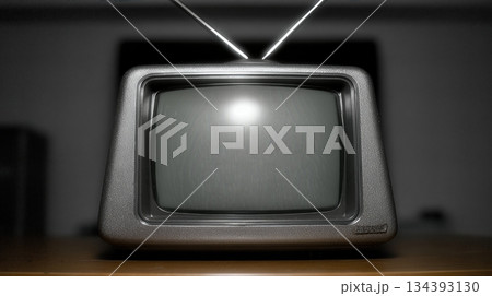 Retro Tv Sits on a Wooden Table With High Contrast Lighting in a Dim Room During the Evening Hours Retro Tv Sits on a Wooden Table With High Contrast Lighting in a Dim Room During the Evening Hours 134393130