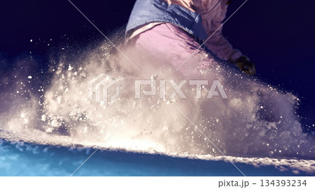 Snowboarder Carving a Turn at High Speed, Sending up a Spray of Snow in the Mountains 134393234