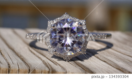 Beautiful White Sapphire Ring With Intricate Design Showcased Outdoors on a Wooden Surface 134393304