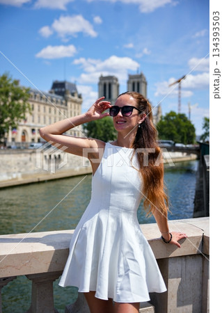 Young woman in white dress posing on river embankment 134393503
