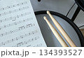 Music practice with drum sticks and sheet music for percussion enthusiasts. International Music Day. Rock-n-Roll Day 134393527