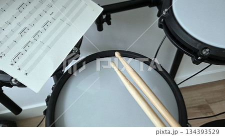 Electric drum set with sheet music and drumsticks for music practice and composition. International Music Day. Rock-n-Roll Day 134393529
