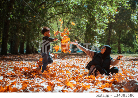 A Joyous Autumn Day A Child and Parent Play with Colorful Leaves A Joyous Autumn Day A Child and Parent Play with Colorful Leaves 134393590