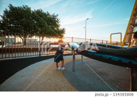 kids playing happily, children interact playfully on swing with sunset and silhouette kids playing happily, children interact playfully on swing with sunset and silhouette 134393806
