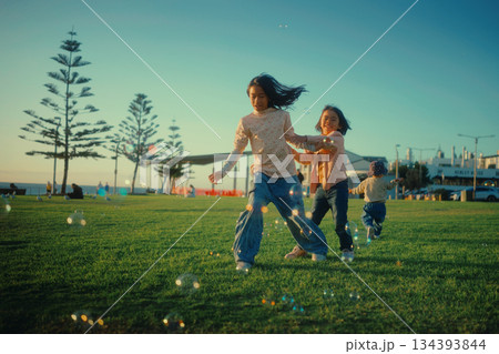 A group of children delightfully enjoying playing with bubbles in the park 134393844