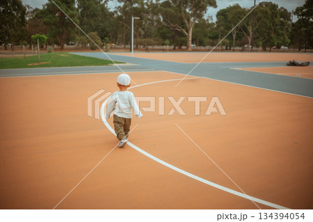 young child on court, toddler in helmet moving playfully in contemporary urban sports 134394054