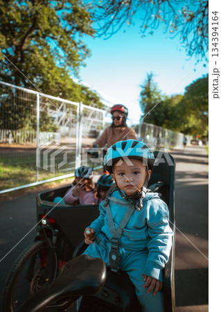 Enjoy a Family Cycling Adventure Children Securely in Safe Bike Seats Enjoy a Family Cycling Adventure Children Securely in Safe Bike Seats 134394164