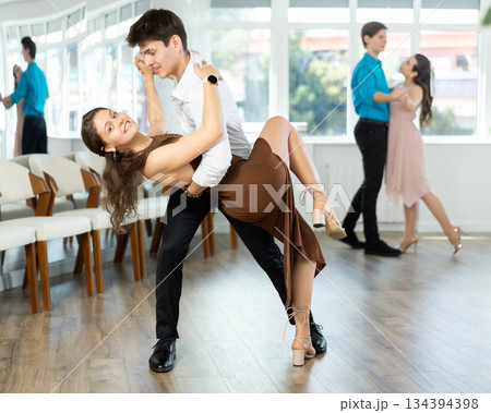 Latin American guy and girl performing kizomba in dance studio 134394398
