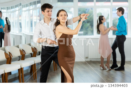 During rehearsal, guy and girl participants of dance workshop perform social pair dance 134394403