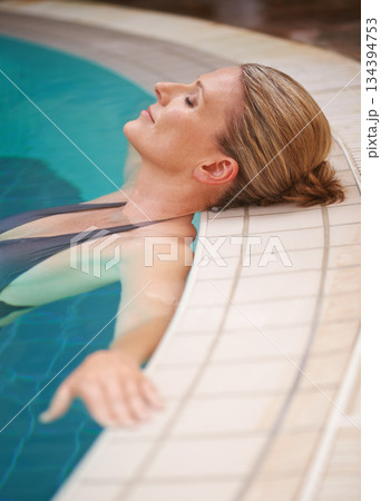 Swimming pool, calm and woman relax on holiday, summer vacation and weekend getaway. Travel, luxury spa hotel and happy female person relaxing in water for happiness, wellness and peace outdoors 134394753