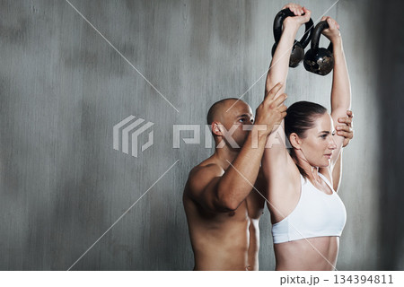Fitness, personal trainer and weightlifting kettlebell in arm workout or exercise together at gym. Fit man coaching woman lifting weight for strong exercising, power or strength training on mockup Fitness, personal trainer and weightlifting kettlebell in arm workout or exercise together at gym. Fit man coaching woman lifting weight for strong exercising, power or strength training on mockup 134394811