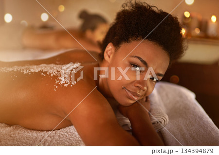 Salt, spa application and black woman portrait of customer at a hotel with lying for massage. Exfoliate therapy, luxury and relax treatment of a female person back for skincare and wellness Salt, spa application and black woman portrait of customer at a hotel with lying for massage. Exfoliate therapy, luxury and relax treatment of a female person back for skincare and wellness 134394879