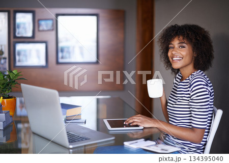 Laptop, tablet and portrait of woman with coffee for work from home opportunity, freelancer career and happy job. Face of young African person on multimedia or digital project and tea for inspiration Laptop, tablet and portrait of woman with coffee for work from home opportunity, freelancer career and happy job. Face of young African person on multimedia or digital project and tea for inspiration 134395040
