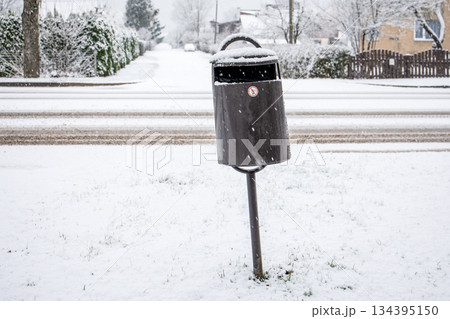 Snow Covered Outdoor Trash Bin Beside Residential Winter Street 134395150