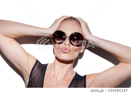Portrait, kiss and sunglasses or trendy woman for fashion in studio or skincare and isolated on white background. Face, stylish and female model for makeup or glamour or lipstick . and fish lips Portrait, kiss and sunglasses or trendy woman for fashion in studio or skincare and isolated on white background. Face, stylish and female model for makeup or glamour or lipstick . and fish lips 134395187