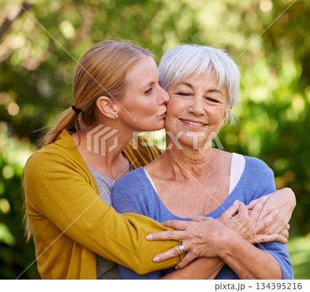 Adult daughter kiss mom, hug and trust with peace outdoor, family spending quality time in garden together. Women are content in relationship with love, bonding and solidarity in nature park 134395216