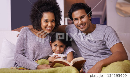 Family, child and reading book portrait in a home for story time on a lounge sofa with a smile. A woman, man or parents and girl child together for development, learning and love with a fantasy Family, child and reading book portrait in a home for story time on a lounge sofa with a smile. A woman, man or parents and girl child together for development, learning and love with a fantasy 134395499
