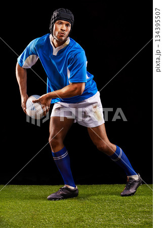 Rugby, dark and man sports athlete pass a ball at night in black studio background training, wellness and fitness. Exercise, workout and professional career of sport male person or player on grass 134395507