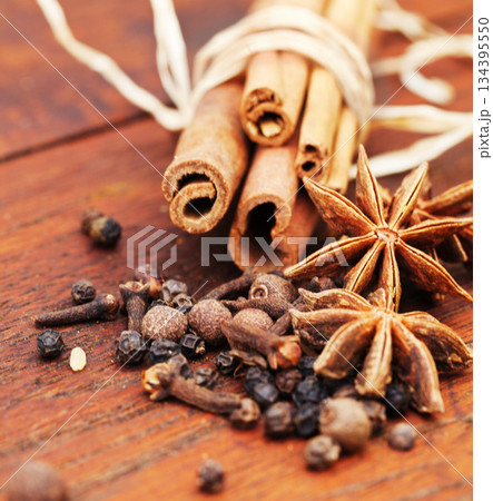 Indian spices, cooking ingredient and table with kitchen herbs for curry and biryani. Wood tabletop, healthy diet and closeup with cinnamon, pepper and cloves for Mediterranean cuisine with cumin Indian spices, cooking ingredient and table with kitchen herbs for curry and biryani. Wood tabletop, healthy diet and closeup with cinnamon, pepper and cloves for Mediterranean cuisine with cumin 134395550