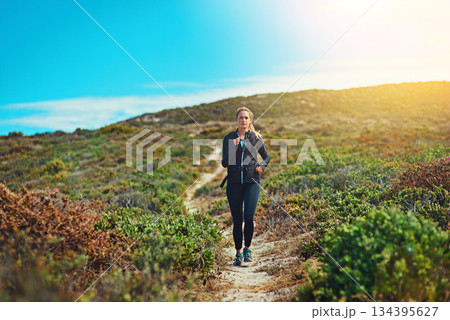 Woman running through field, fitness outdoor with cardio and training for marathon with young athlete and sports. Female runner in nature, hiking trail and run for exercise, healthy and active person Woman running through field, fitness outdoor with cardio and training for marathon with young athlete and sports. Female runner in nature, hiking trail and run for exercise, healthy and active person 134395627