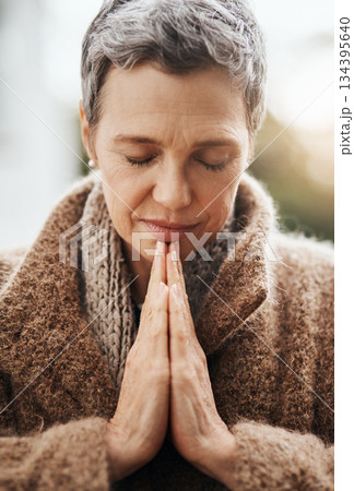 Senior woman is praying, hands with worship and religion, God with peace, gratitude and faith outdoor. Spiritual female person in nature with face, eyes closed and prayer for guidance and blessing 134395640