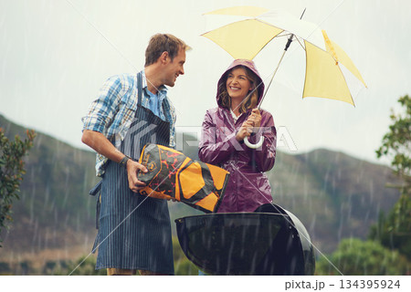 Man, woman and barbecue in rain with umbrella, charcoal or surprise on vacation with love in garden. Couple, outdoor and grill in storm, backyard or cooking in winter with helping hand, wind or smile Man, woman and barbecue in rain with umbrella, charcoal or surprise on vacation with love in garden. Couple, outdoor and grill in storm, backyard or cooking in winter with helping hand, wind or smile 134395924