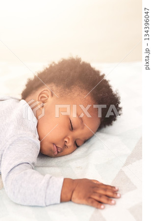 Cute, bed and baby sleeping in home on blanket for rest, nap time and dreaming in nursery. Childcare, newborn and adorable, tired and African child in bedroom sleep for comfort, relaxing and calm 134396047